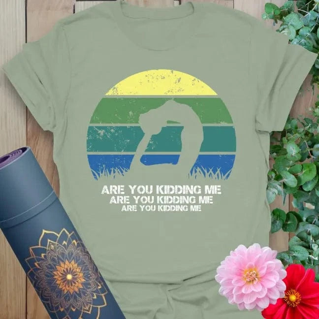 Calm sage green yoga t-shirt with retro playful yoga artwork and funny "Are You Kidding Me" quote for light-hearted mindful movement.