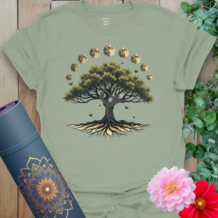 Calm sage green yoga t-shirt featuring rooted tree and lunar phase artwork for grounded, heart-centered living.