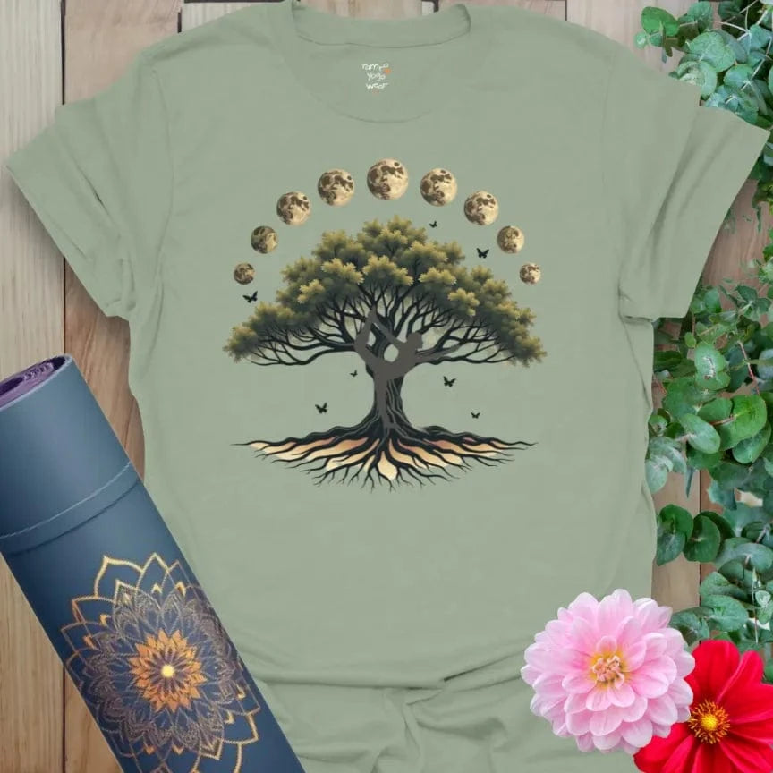 Calm sage green yoga t-shirt featuring rooted tree and lunar phase artwork for grounded, heart-centered living.