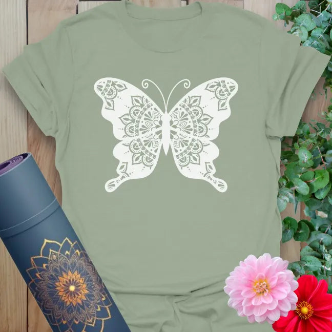Calm sage green yoga t-shirt featuring sacred butterfly mandala artwork for grounded, soulful expression.