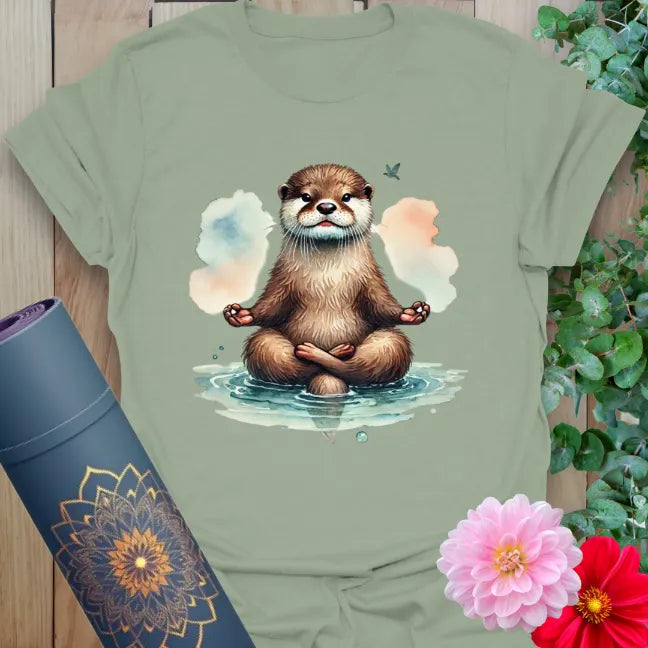Calm sage green yoga t-shirt featuring meditating otter artwork symbolizing curiosity, peaceful living, and nature-connected mindfulness.