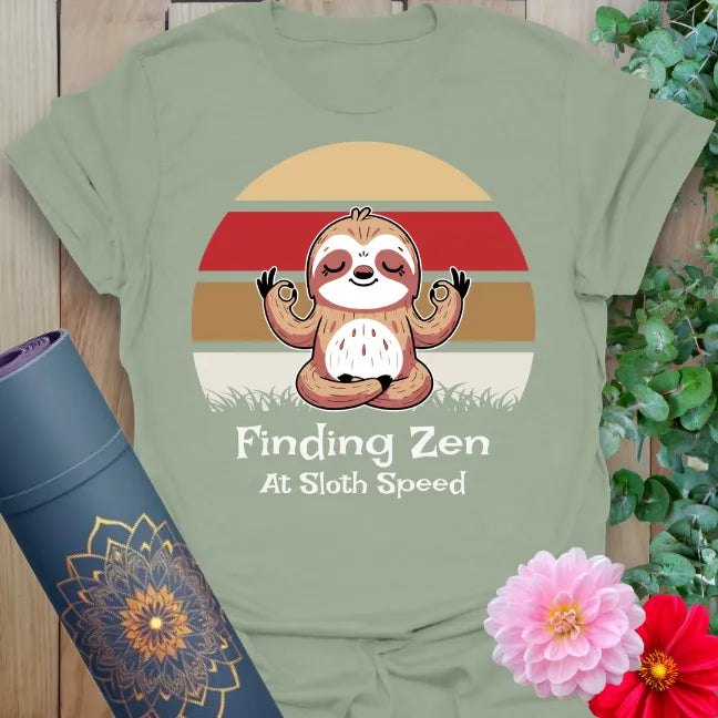 Calm sage green yoga t-shirt featuring serene sloth illustration and "Finding Zen at Sloth Speed" message for grounded, joyful mindfulness.