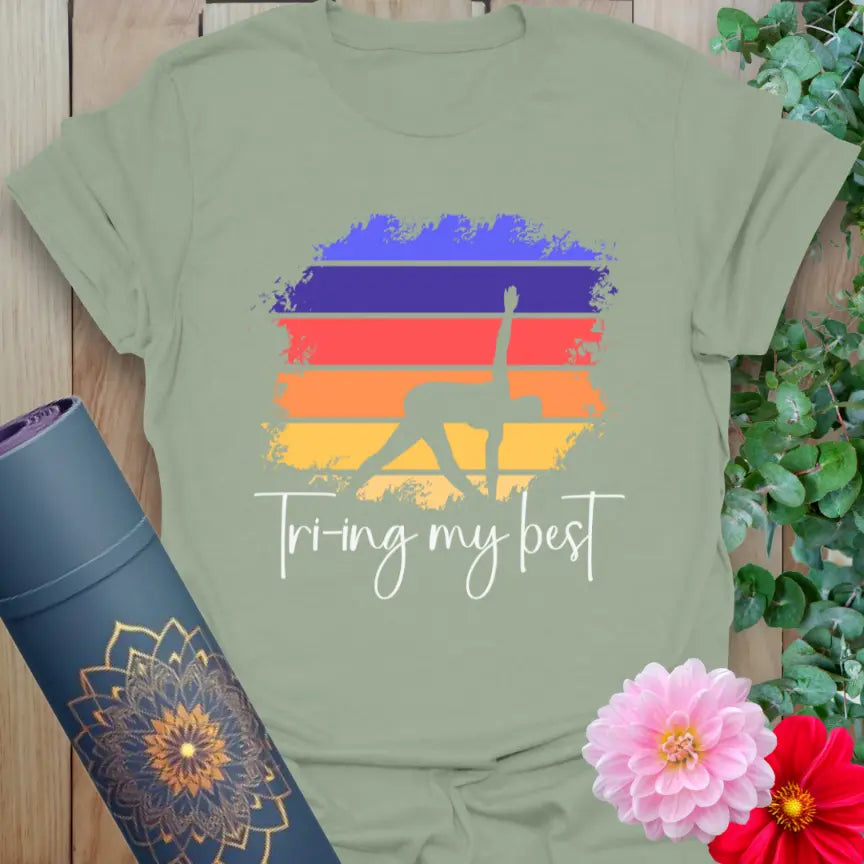Sage green yoga tee with Triangle Pose figure and bright gradient backdrop, perfect for growth-minded, real-world yogis.