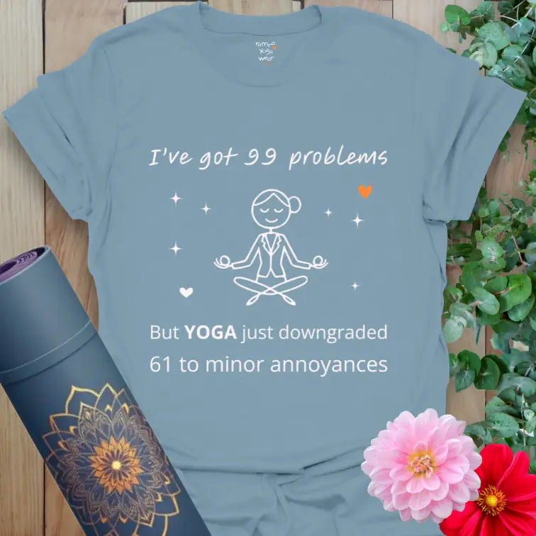 Stone Blue 99 Problems T-Shirt with witty line “I’ve got 99 problems but YOGA just downgraded 61 to minor annoyances.”
Simple yogi line art and orange heart accent for calm humor.