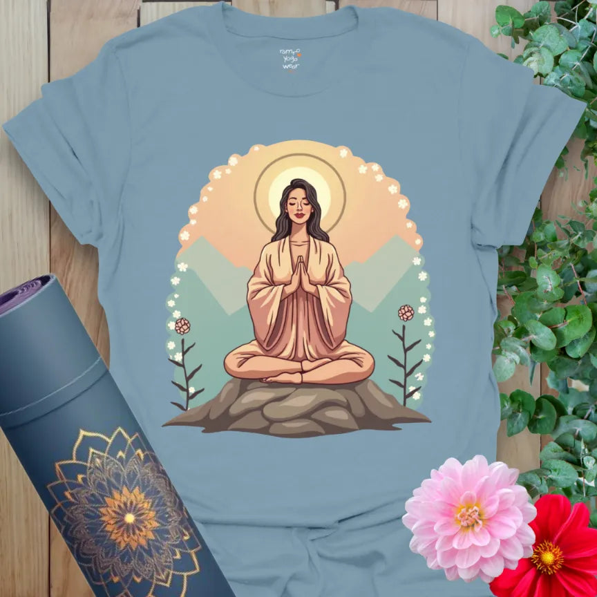 Muted stone blue yoga t-shirt featuring serene meditation artwork with mountain backdrop and halo for conscious connection.