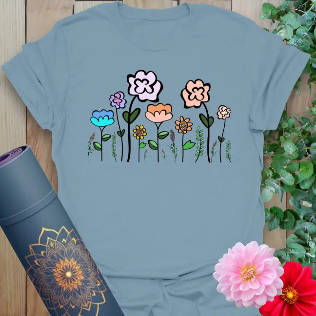 Muted stone blue yoga t-shirt featuring playful wildflower design for earth-connected movement and soulful expression.