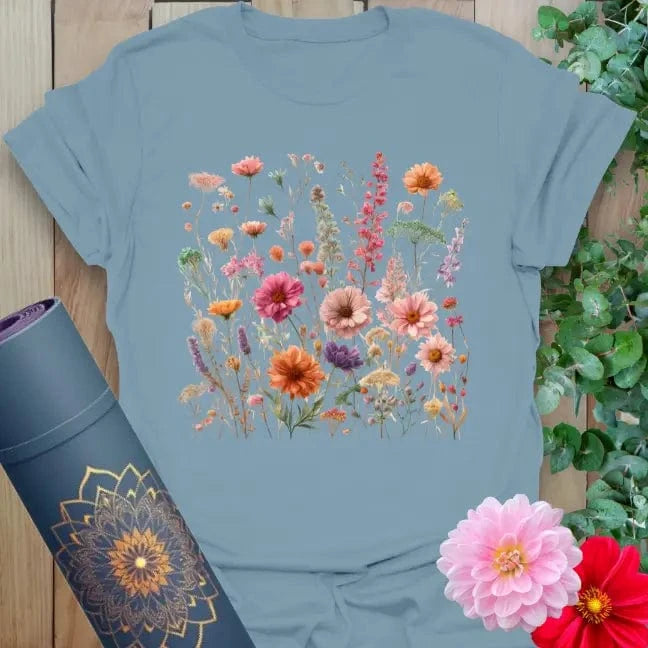 Muted stone blue yoga t-shirt featuring bright field of wildflowers and gerbera daisies for conscious, soulful expression.