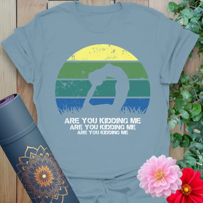 Muted stone blue yoga t-shirt featuring fun yogi silhouette and colorful sunset backdrop for joyful, conscious living.