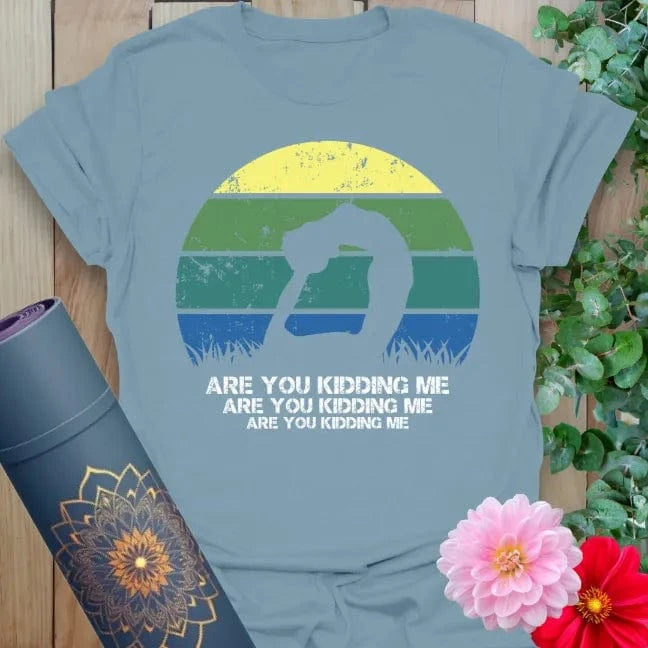 Muted stone blue yoga t-shirt featuring fun yogi silhouette and colorful sunset backdrop for joyful, conscious living.