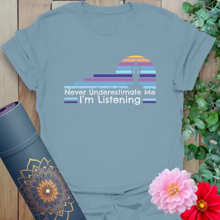 Muted stone blue yoga t-shirt with soulful retro sunset and "Never Underestimate Me" mindful living affirmation.