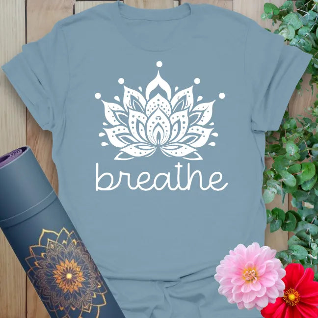 Muted stone blue yoga t-shirt featuring intricate lotus flower and "breathe" message for soulful, mindful movement.