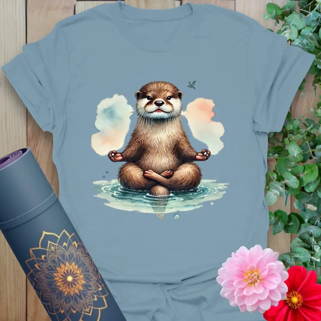 Muted stone blue yoga t-shirt featuring whimsical otter meditation illustration for conscious, creative, and joyful living.