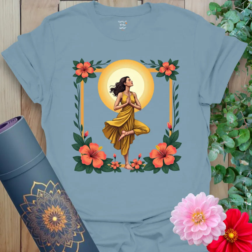 Muted stone blue yoga t-shirt with vibrant yogi, floral, and sun artwork symbolizing rootedness, growth, and inner light.