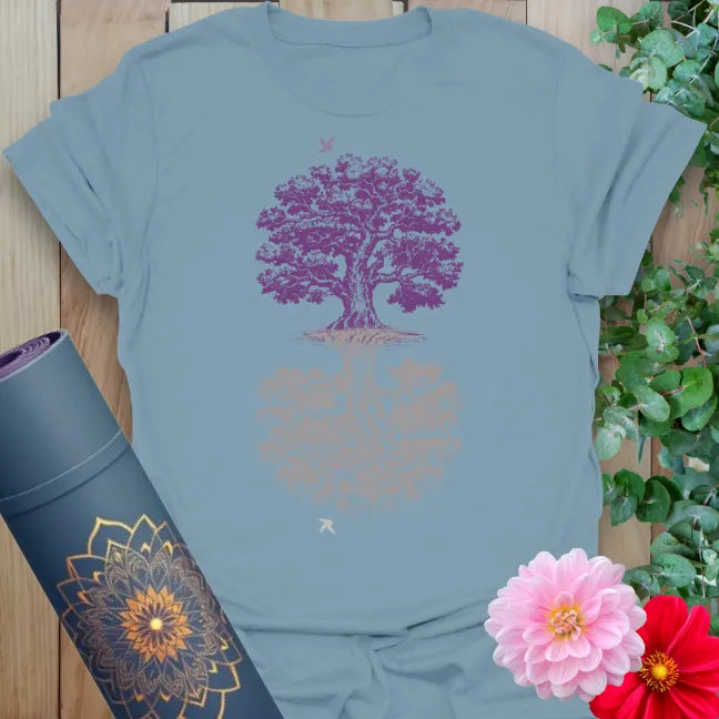 Muted stone blue yoga t-shirt with mirrored tree of life design symbolizing reflection, balance, and heart-centered growth.