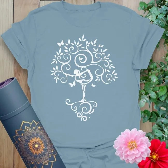Muted stone blue yoga tee with blooming tree and yogi in Tree Pose, ideal for grounding energy and intentional living.