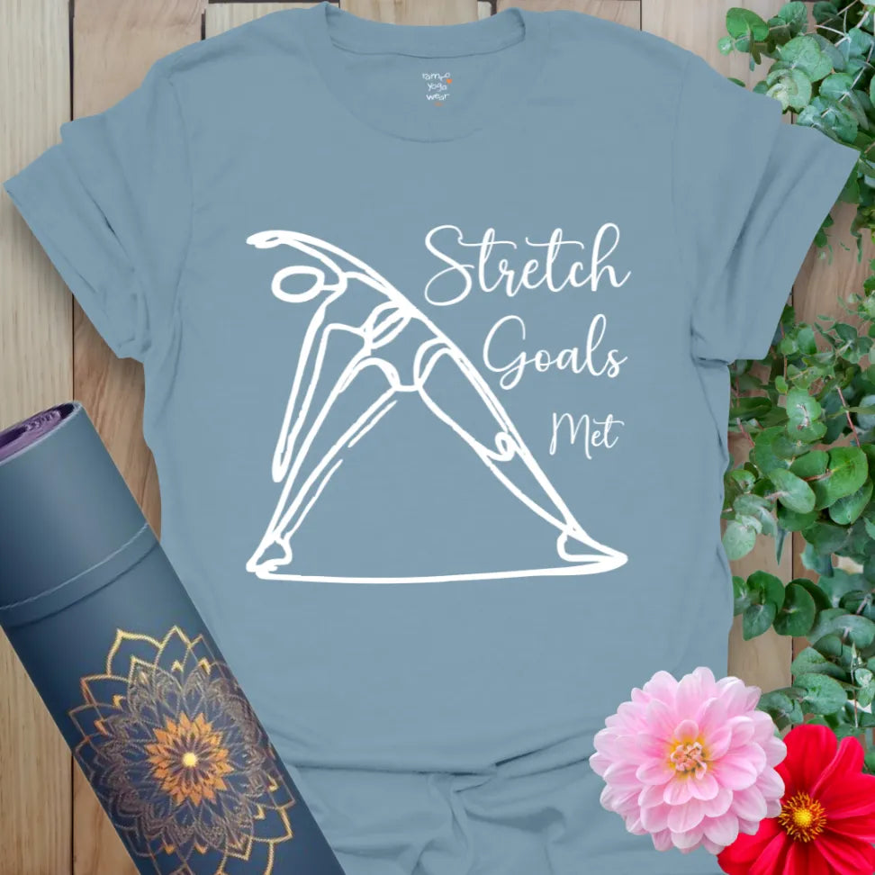 Muted stone blue yoga tee with elegant stretch illustration and “Stretch Goals Met” text, made for yogis with humor and heart.