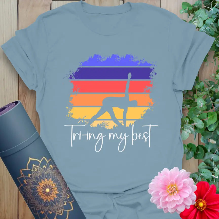 Muted stone blue yoga t-shirt featuring yogi in Triangle Pose with brushstroke background for effortful, soulful style.