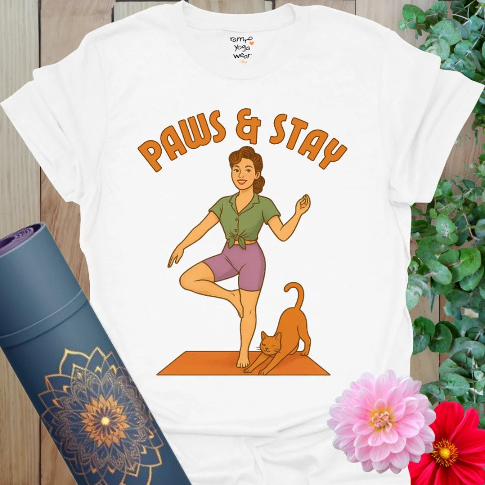 White cotton yoga tee with vintage-style yogi in tree pose beside a stretching cat and “Paws & Stay” text.