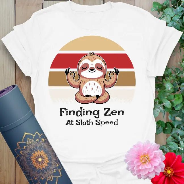 Clean white unisex yoga t-shirt featuring adorable sloth meditation artwork and mindfulness reminder for slow, steady soulful living.