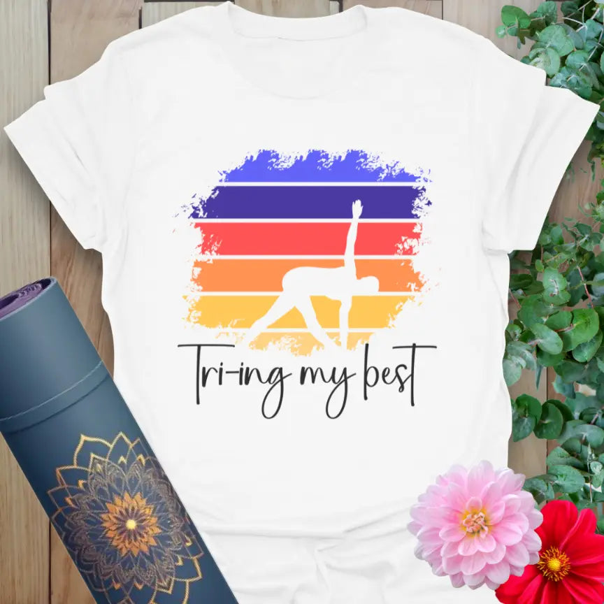 Clean white unisex yoga tee with colorful Triangle Pose design and “Trying My Best” text for self-love and presence.