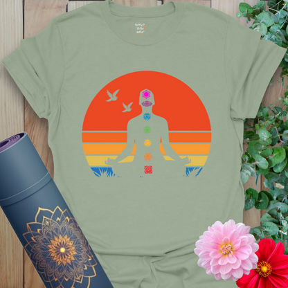 Flatlay of sage green 7 Chakra T-Shirt with colorful chakra design and meditating figure crafted by Ramro Yoga Wear.