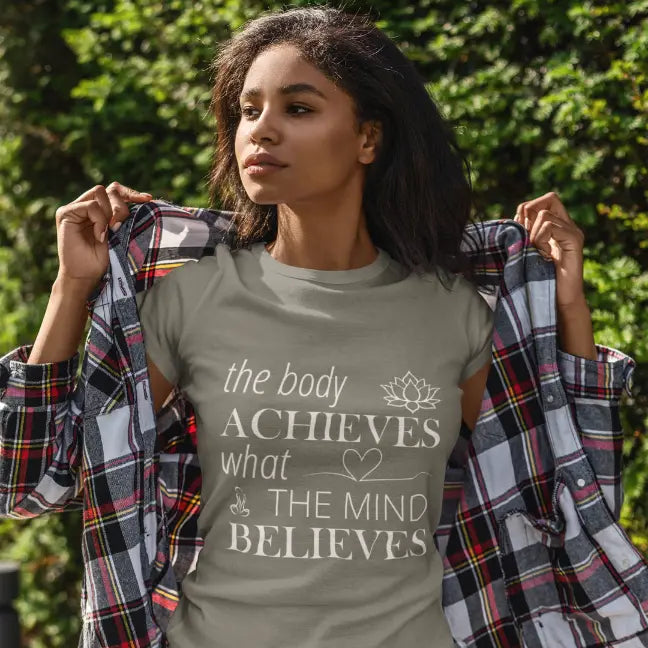 Woman wearing Achieve T-Shirt Heather Military Green outdoors, hand raised, trees in background by Ramro Yoga Wear from The Vault Collection