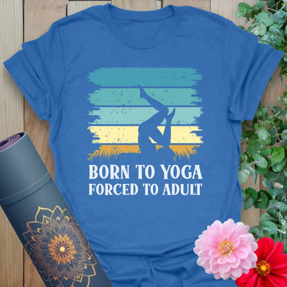 Flatlay of heather royal blue Adult T-Shirt with vintage-style “Born to Yoga, Forced to Adult” print.
