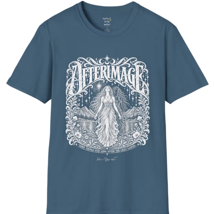 A short sleeved tee called the Afterimage T-Shirt, flat lay and a Gildan 64000 shirt on a white background. Simply says, Some Things Stay Long After The Light Leaves. Design highlights a long-haired figure in a flowing gown standing before a faint ghosted double of herself, under a starry sky with mountains, a lake and an ornate floral frame. Color is Indigo Blue.