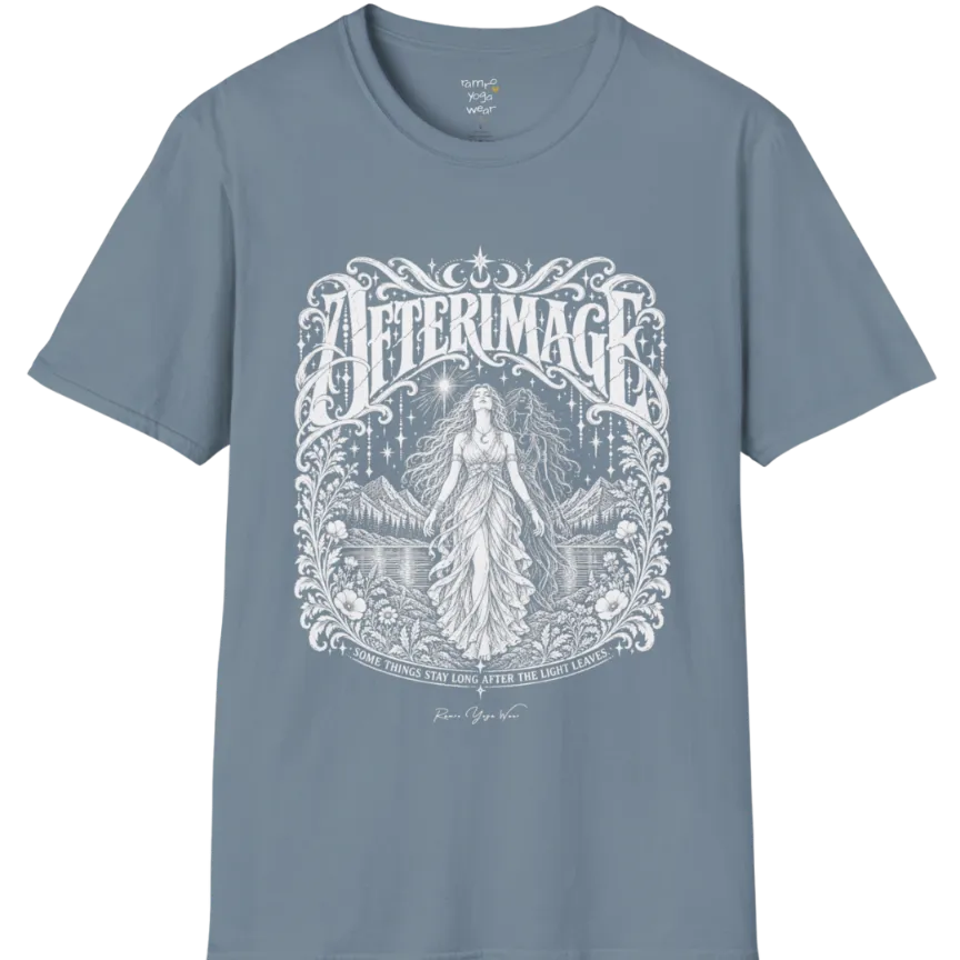 A short sleeved tee called the Afterimage T-Shirt, flat lay and a Gildan 64000 shirt on a white background. Simply says, Some Things Stay Long After The Light Leaves. Design highlights a long-haired figure in a flowing gown standing before a faint ghosted double of herself, under a starry sky with mountains, a lake and an ornate floral frame. Color is Stone Blue.