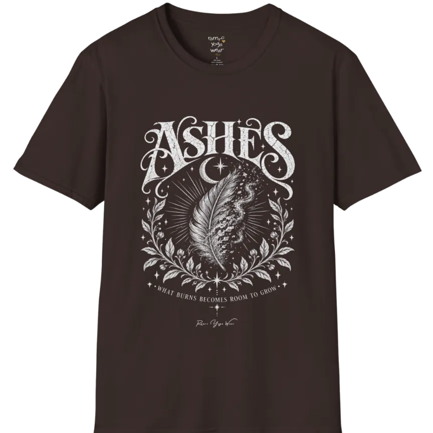 A single feather transforming into ash and ember against a dark starlit background, botanical framing below. Ashes T-Shirt flat lay is a Gildan 64000 and the color is Dark Chocolate.
