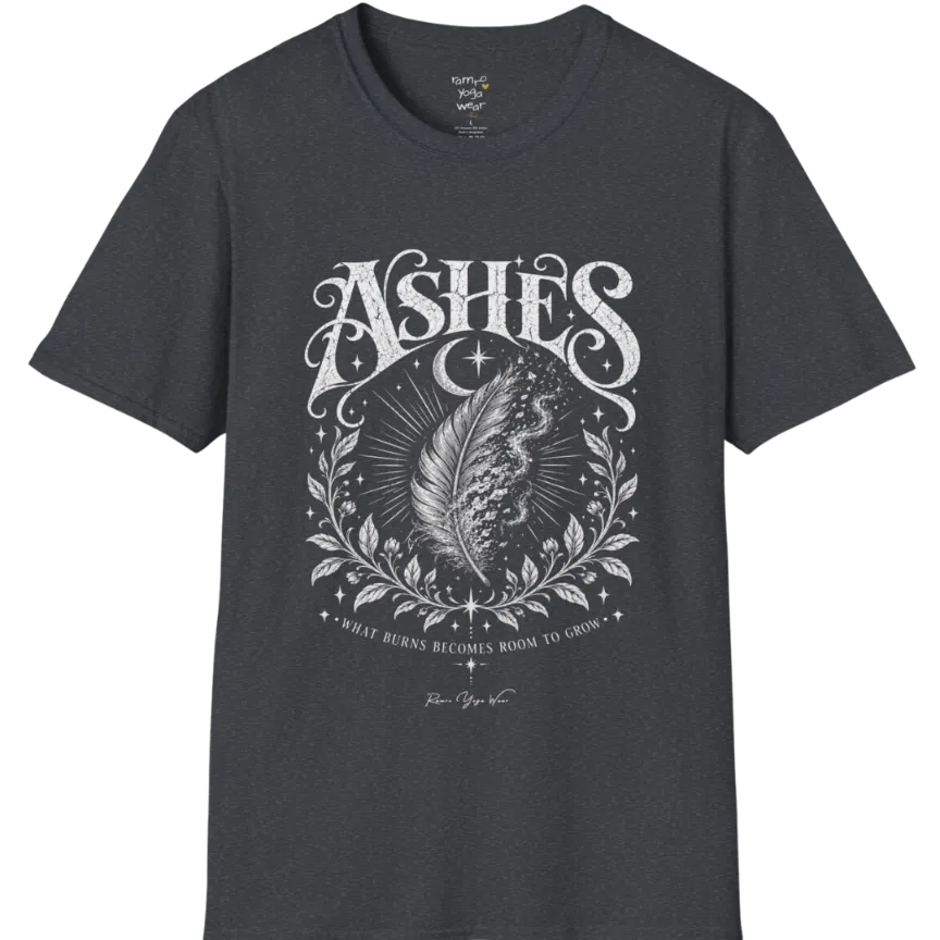 A single feather transforming into ash and ember against a dark starlit background, botanical framing below. Ashes T-Shirt flat lay is a Gildan 64000 and the color is Dark Heather Grey.