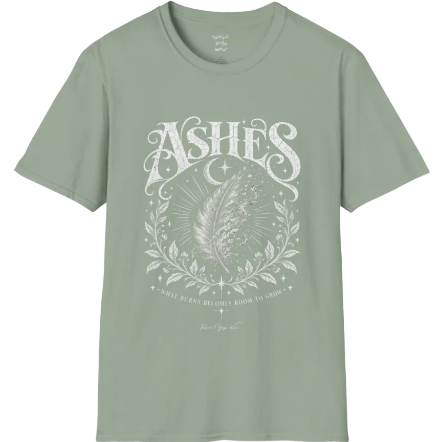 A single feather transforming into ash and ember against a dark starlit background, botanical framing below. Ashes T-Shirt flat lay is a Gildan 64000 and the color is Sage.