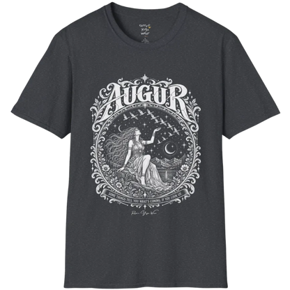 A short sleeved tee called the Augur T-Shirt, flat lay and a soft cotton blend shirt. Simply says, Some things tell you what's coming, if you look up. Design highlights an ornate engraved circular frame of florals and filigree around a long-haired figure in a flowing gown seated on a rocky ledge, one hand raised toward a flock of birds crossing a starry sky, with crescent moons, mountains and still water behind and Augur in decorative lettering across the top. Color is Dark Heather Grey. 