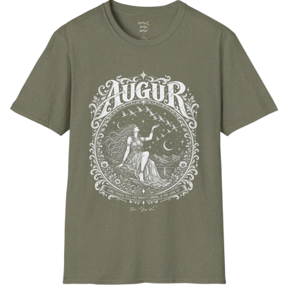 A short sleeved tee called the Augur T-Shirt, flat lay and a soft cotton blend shirt. Simply says, Some things tell you what's coming, if you look up. Design highlights an ornate engraved circular frame of florals and filigree around a long-haired figure in a flowing gown seated on a rocky ledge, one hand raised toward a flock of birds crossing a starry sky, with crescent moons, mountains and still water behind and Augur in decorative lettering across the top. Color is Heather Military Green. 