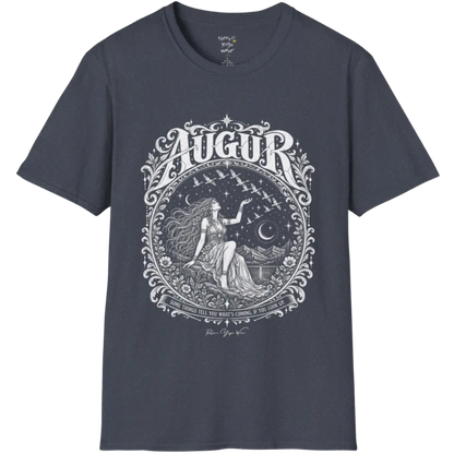 A short sleeved tee called the Augur T-Shirt, flat lay and a soft cotton blend shirt. Simply says, Some things tell you what's coming, if you look up. Design highlights an ornate engraved circular frame of florals and filigree around a long-haired figure in a flowing gown seated on a rocky ledge, one hand raised toward a flock of birds crossing a starry sky, with crescent moons, mountains and still water behind and Augur in decorative lettering across the top. Color is Heather Navy.