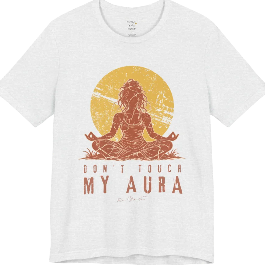 A short sleeved teed called the Aura T-Shirt, flat lay and a Bella + Canvas 3001 shirt. Simply says, Don't Touch My Aura. Design highlights a person meditating with a large bright sun in the background, all in a rustic, distressed illustration. Color is Ash.