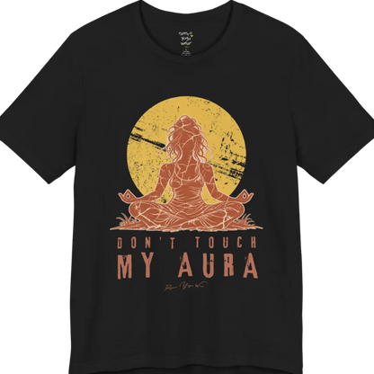 A short sleeved teed called the Aura T-Shirt, flat lay and a Bella + Canvas 3001 shirt. Simply says, Don't Touch My Aura. Design highlights a person meditating with a large bright sun in the background, all in a rustic, distressed illustration. Color is  Black.