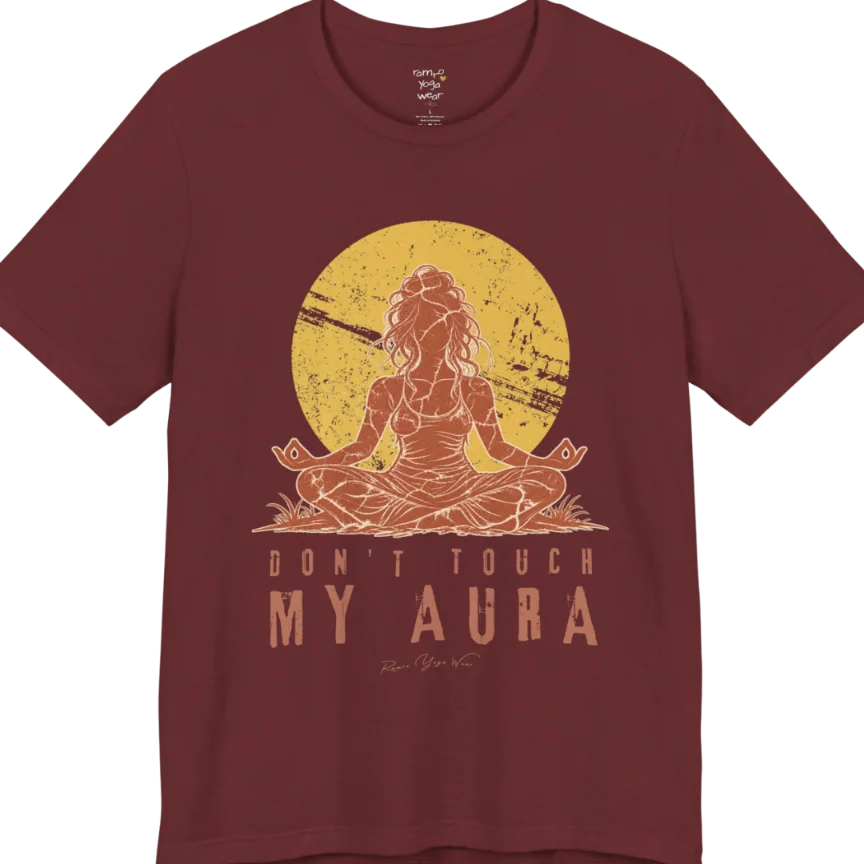A short sleeved teed called the Aura T-Shirt, flat lay and a Bella + Canvas 3001 shirt. Simply says, Don't Touch My Aura. Design highlights a person meditating with a large bright sun in the background, all in a rustic, distressed illustration. Color is Heather Cardinal.