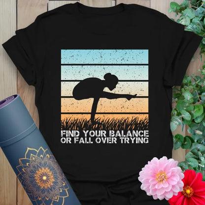 Black yoga t-shirt with sunset silhouette and “Find your balance or fall over trying” quote
