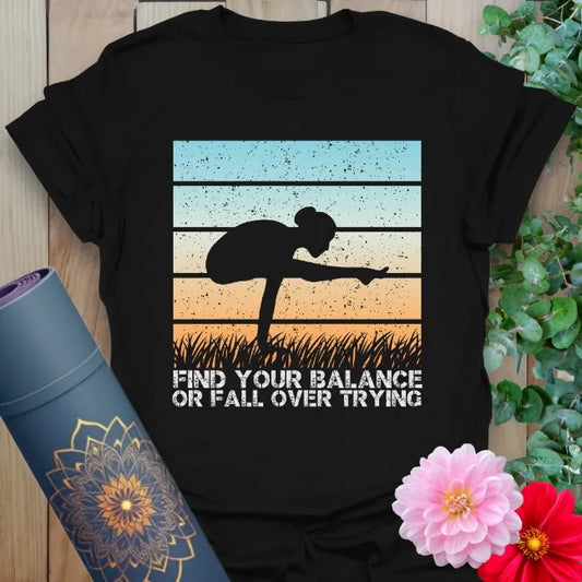 Black yoga t-shirt with sunset silhouette and “Find your balance or fall over trying” quote