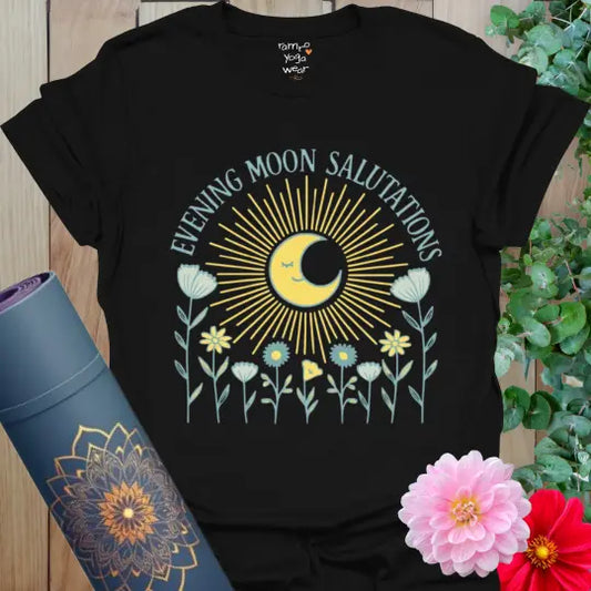 Black Evening Moon Salutations T-Shirt with radiant golden moon and muted floral detailing. A soulful yoga tee for evening practice and reflection.