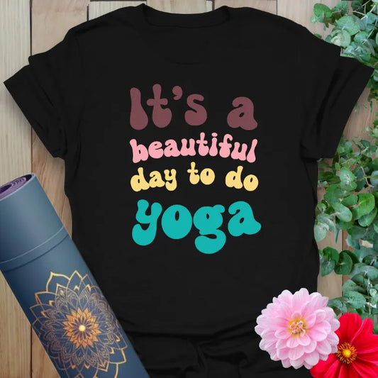 Classic black cotton tee with bright retro typography saying “It’s a Beautiful Day to Do Yoga” for bold, soulful style.