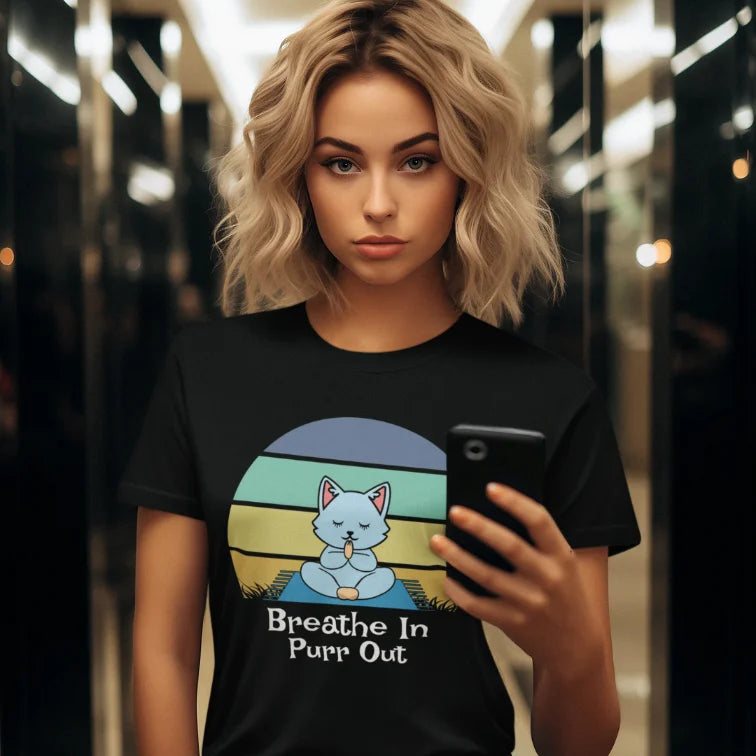 Woman wearing Black Breathe In T-Shirt featuring retro yoga cat artwork in warm editorial lifestyle setting.