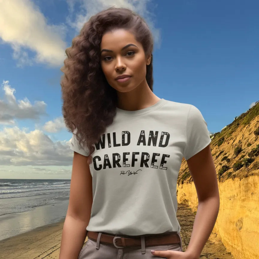 Person wearing Carefree tee in color Ash, a sacred yoga shirt on a coastal cliff by the beach — Funny Yoga Shirts collection by Ramro Yoga Wear