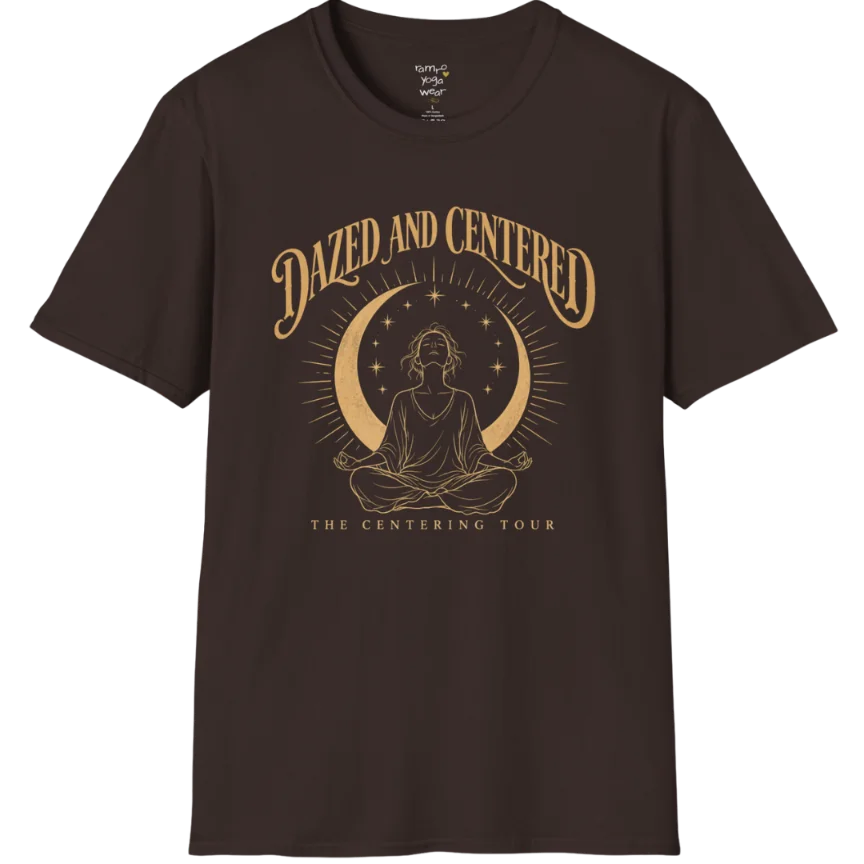 A short sleeved tee called the Centered T-Shirt, flat lay and a soft cotton shirt. Simply says, Dazed and Centered, The Centering Tour. Design highlights a person meditating in lotus pose beneath a gold crescent moon with radiating rays and a ring of small stars. Color is Dark Chocolate.
