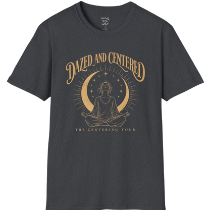 A short sleeved tee called the Centered T-Shirt, flat lay and a soft cotton shirt. Simply says, Dazed and Centered, The Centering Tour. Design highlights a person meditating in lotus pose beneath a gold crescent moon with radiating rays and a ring of small stars. Color is Dark Heather Grey.