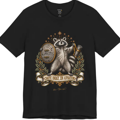 Illustrated raccoon crest holding a shield stamped "Namaste" and a rolled yoga mat, framed by stars and botanical laurel branches. Chaotic Zen T-Shirt flat lay is a Bella+Canvas 3001 and the color in Black.