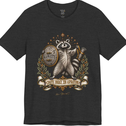 Illustrated raccoon crest holding a shield stamped "Namaste" and a rolled yoga mat, framed by stars and botanical laurel branches. Chaotic Zen T-Shirt flat lay is a Bella+Canvas 3001 and the color in Dark Grey Heather.