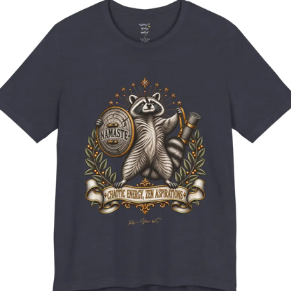 Illustrated raccoon crest holding a shield stamped "Namaste" and a rolled yoga mat, framed by stars and botanical laurel branches. Chaotic Zen T-Shirt flat lay is a Bella+Canvas 3001 and the color in Heather Midnight Navy.