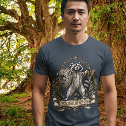 A man stands among large trees in a wooded area, wearing the Chaotic Zen T-Shirt. Chaotic Zen T-Shirt is a Bella+Canvas 3001 and the color in Heather Midnight Navy color.